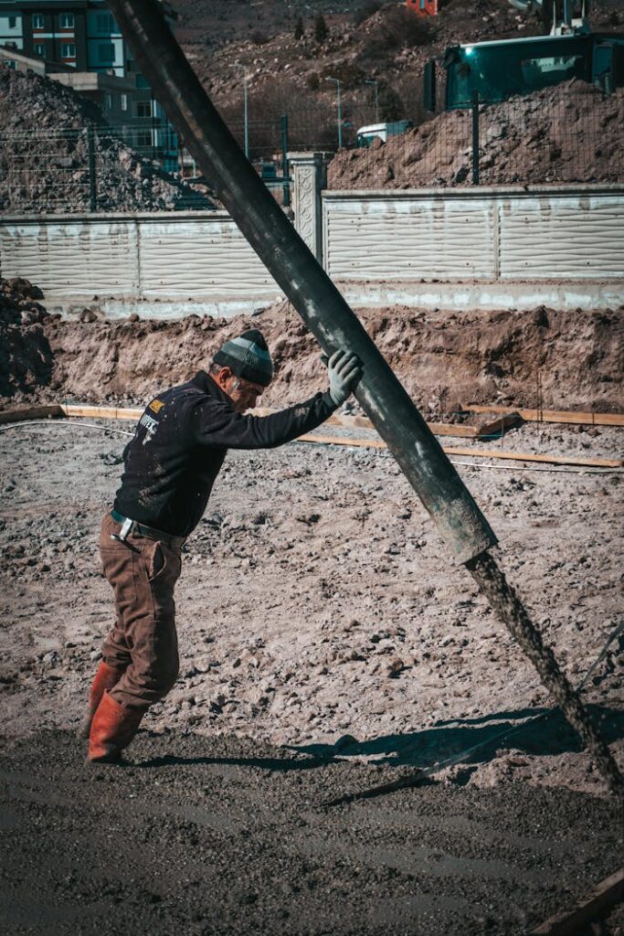 Worker pouring concrete at a construction site in Türkiye, illustrating urban development.